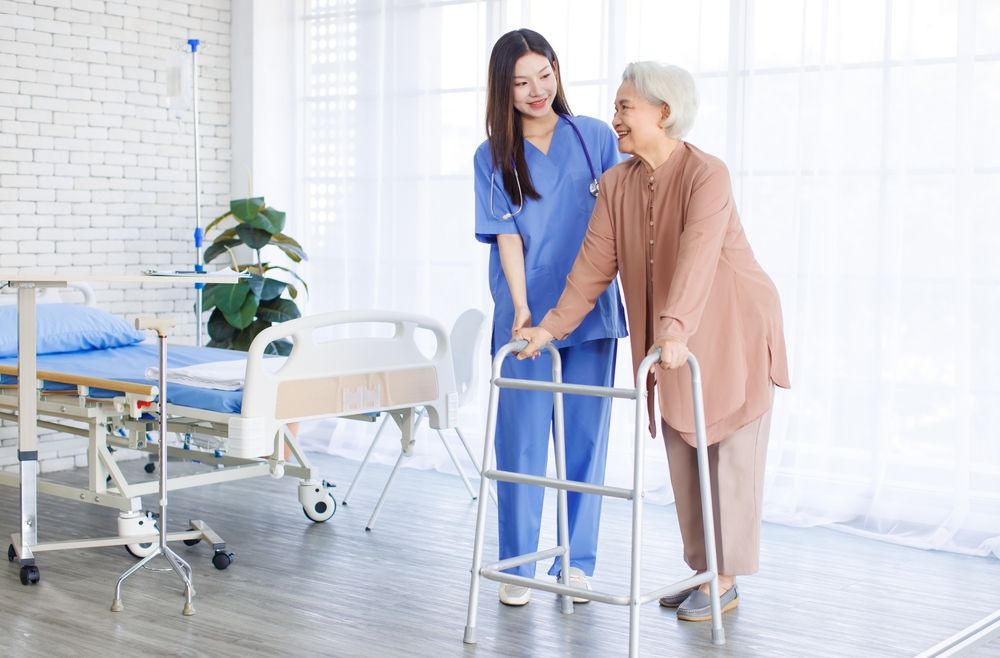 Young nurse supporting senior patient walk slowly